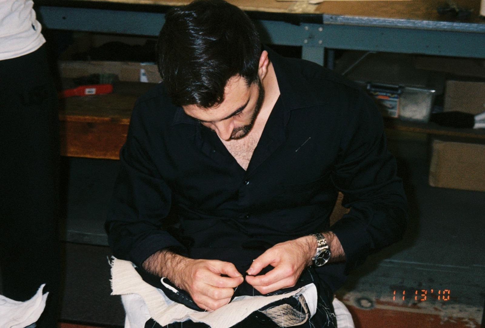 Tristan Michael hand sewing a bespoke garment in his New York tailoring practice.